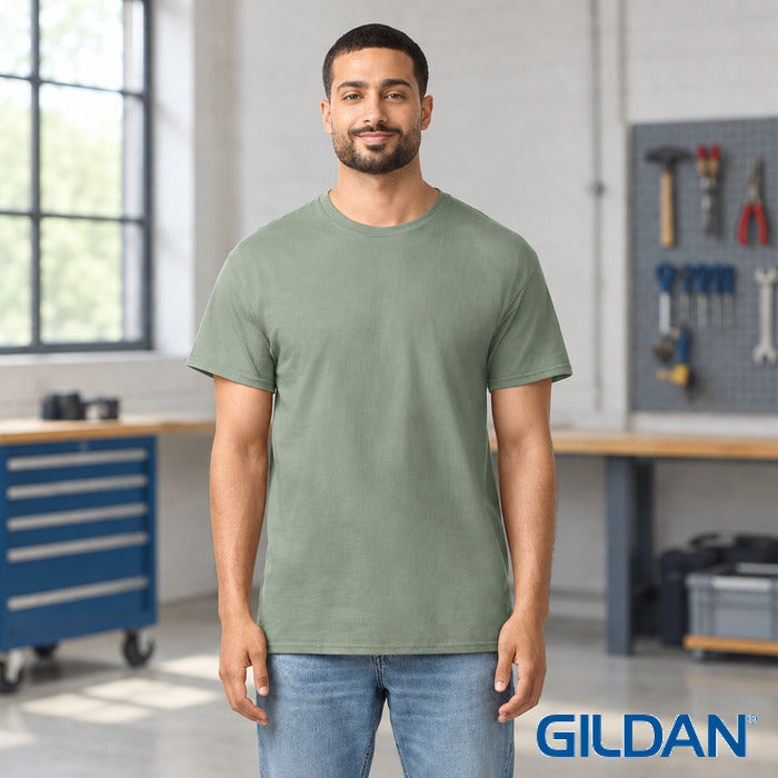 Light Cotton Adult T-Shirt - model wearing the sage green tee in a workshop
